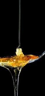 Golden honey flows elegantly from a spoon against a black background.