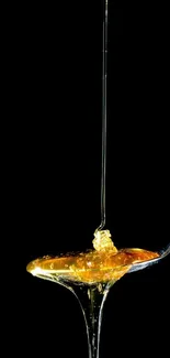 Golden honey drizzling on a silver spoon with black background.