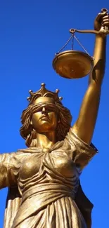 Lady Justice statue with scales against a blue sky.