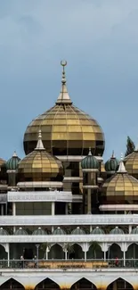 Golden domed mosque with blue sky background.