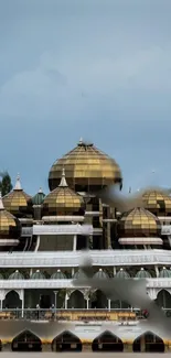 Golden domes of a mosque under a serene blue sky.
