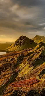 Golden mountains and hills under a dramatic sky at sunset.