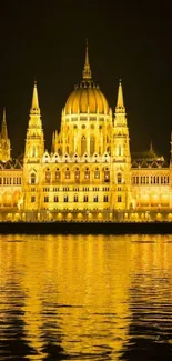 Golden illuminated historic building reflecting on water.