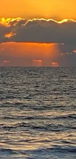 Golden sunset over a calm ocean with waves and glowing sky.