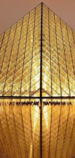 Golden pyramid with reflection under warm light, creating an elegant design.