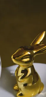 Golden rabbit figurine on minimalist background for mobile wallpaper.