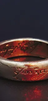 Golden ring with inscription on dark surface