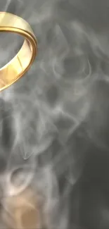 Golden ring amidst swirling smoke on dark background.