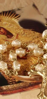 Golden religious icon with rosary beads on a wooden background.