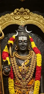 Statue of Lord Shiva in a golden shrine with intricate details.