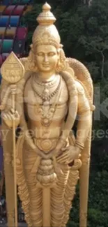 Golden statue with vibrant temple steps and lush greenery.