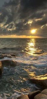 Golden sunset over ocean waves and rocky shore.