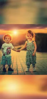 Two children holding hands under a stunning sunset.