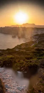 Golden sunset over ocean cliffs and landscape.