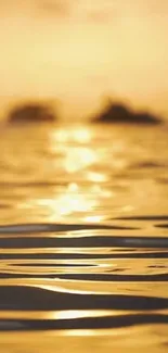 Golden sunset over a calm ocean with reflective waters.