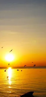 Golden sunset over ocean with birds flying.