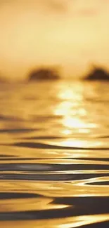 Serene golden ocean sunset with light reflections on water.