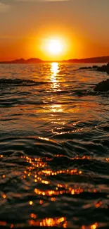 Sunset over ocean with golden reflections and serene waves.