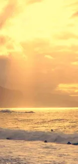 Golden sunset over ocean with serene waves and a glowing sky.