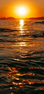 Vibrant golden sunset reflecting on calm ocean waves.