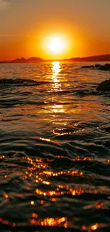 Golden sunset over a tranquil ocean with sun reflections on the water.