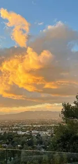 Golden sunset over cityscape with clouds and trees.