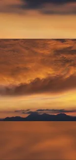 Golden sunset over dark mountain silhouettes with vibrant orange sky.