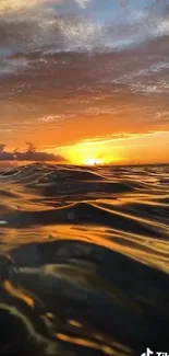 Golden sunset over ocean waves with vibrant sky.