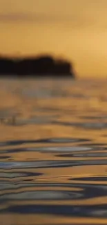 Golden sunset reflecting on calm water surface, creating a serene scene.