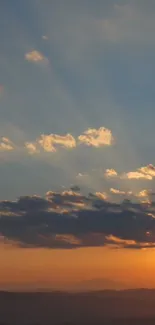 Golden sunset over mountains with vibrant sky and clouds.