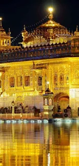 Golden Temple lit up at night with water reflection.