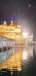 Golden Temple lit at night with starry sky reflection on water.