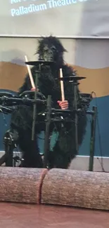 Gorilla in costume playing drums on stage, creating a whimsical scene.