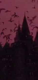 Silhouette of gothic castle against red sky with flying bats.