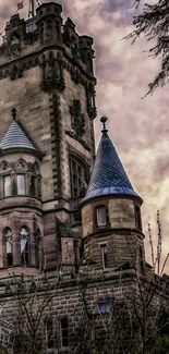 A gothic castle tower against a moody sunset sky.