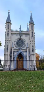 Stunning Gothic cathedral with spires and serene garden setting in mobile wallpaper.