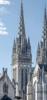 Gothic cathedral spires against a clear blue sky.