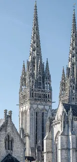Gothic cathedral spires under a clear blue sky.