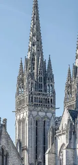 Gothic cathedral spires against blue sky.