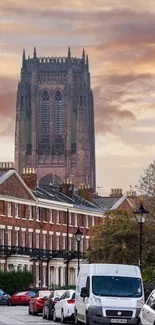 Gothic cathedral rises over urban street scene at sunset.