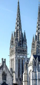 Gothic cathedral spires against blue sky.