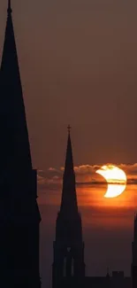 Gothic cathedral spires silhouetted against a vibrant sunrise.