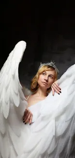 Woman in white angelic wings and crown against dark background.