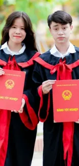 Graduates holding diplomas in vibrant red