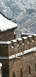 Snow-capped Great Wall of China with scenic mountain backdrop.