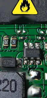 Close-up of green circuit board with micro components and a warning sign.