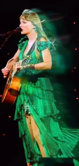 Vibrant green dressed performer on stage with guitar under dynamic lights.