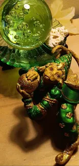 Green jester figurine with crystal ball on wood.