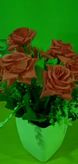 Vibrant orange roses in a white vase on a green background.