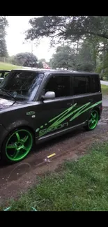 Dark car with neon green rims and decals parked on a rainy street.